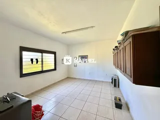 Uma sala de estar com piso de cerâmica e janela na parede.