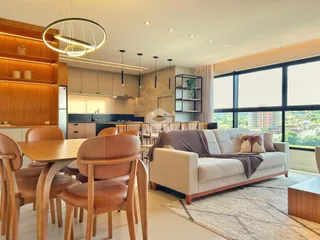 Sala de estar com mesa de jantar e cozinha moderna em Lajeado.