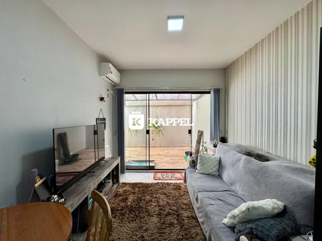 Sala de estar com sofá cinza e televisão.