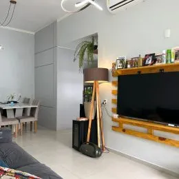 Sala de estar moderna com televisão montada na parede.