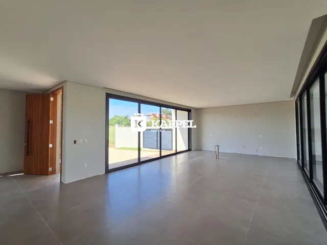 Esta é uma sala ampla com piso de concreto e grandes portas de vidro.