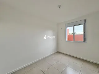 Parede interna de um cômodo com piso de cerâmica e uma janela.