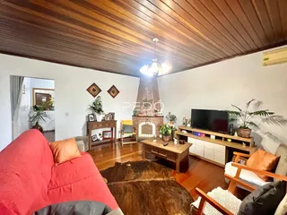 Sala de estar com piso de madeira e lareira em Lajeado, Brasil.