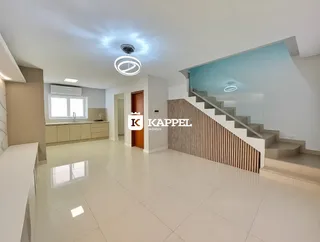 Vista interna de um ambiente amplo com piso de porcelanato claro e iluminação embutida.