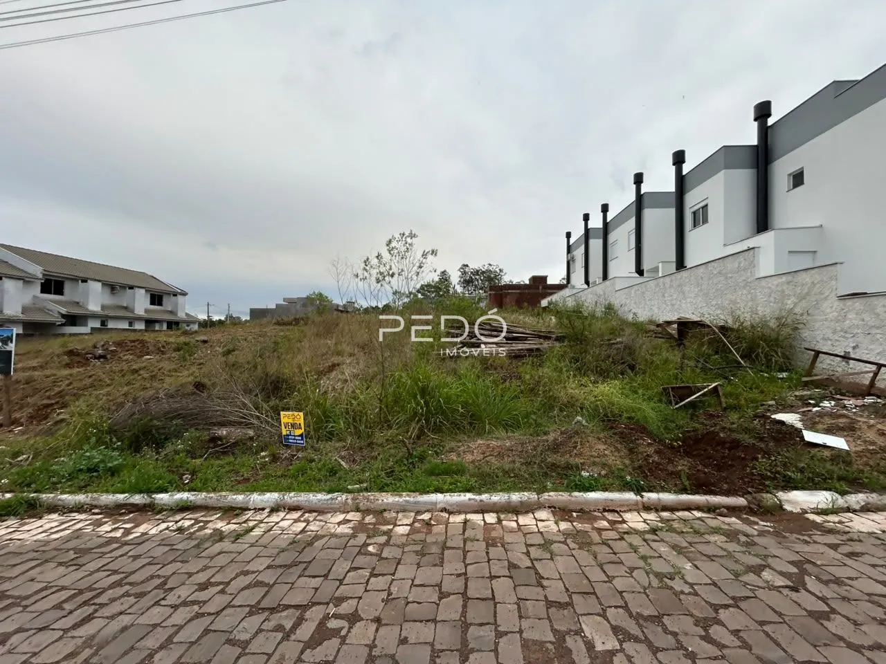 Vista externa de um imóvel com área de vegetação ao redor.