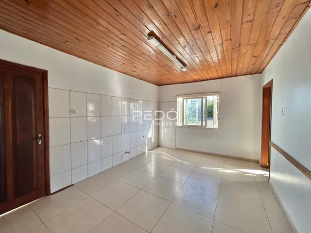 Interior de uma área comum com piso de cerâmica e teto de madeira clara.