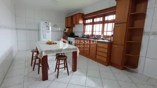 Foto de uma sala de jantar com armários de madeira e piso de cerâmica.