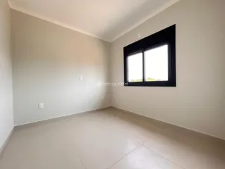 Foto de um cômodo interno com paredes claras e uma grande janela.