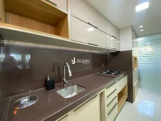 Cozinha moderna com armários e bancada em tons terrosos.