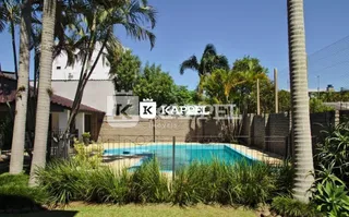 Piscina externa com vegetação ao redor em uma propriedade em Lajeado.