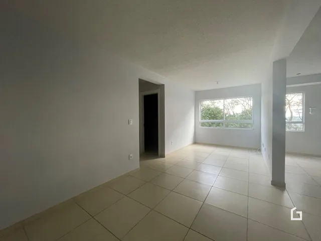 Vista interna de um ambiente com piso de cerâmica e paredes brancas.