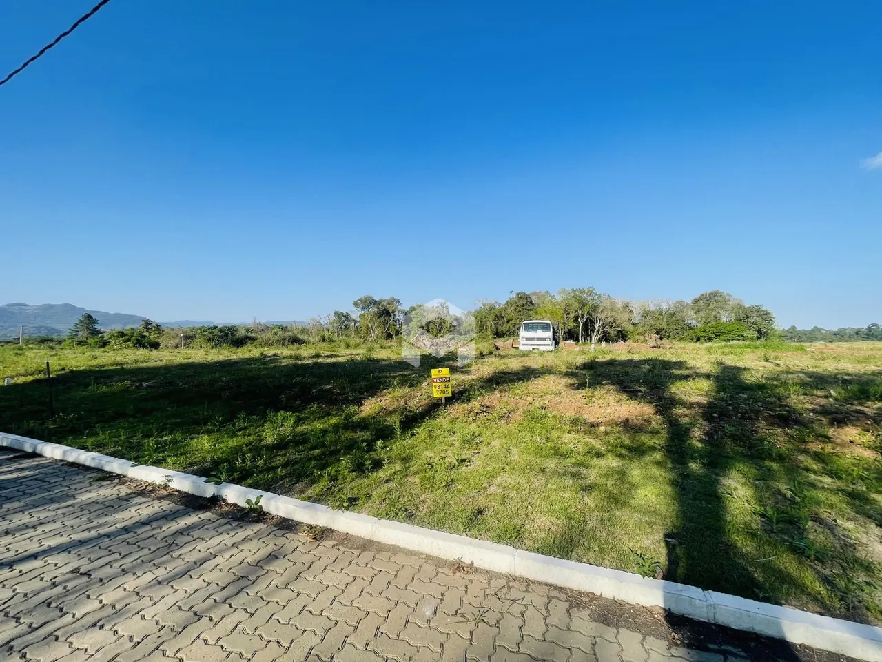 Vista externa de um terreno com vegetação e cerca no Brasil.