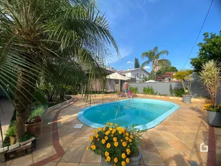 Vista externa de uma piscina e jardim em uma residência no Brasil.