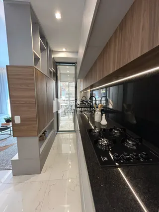 Vista da cozinha moderna com armários de madeira e bancada escura.