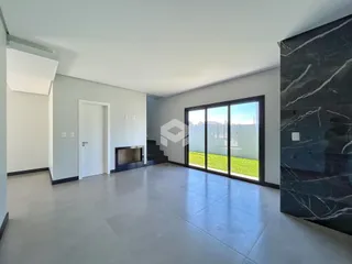 Sala de estar com grandes janelas que dão para o jardim.