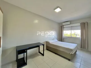 Um quarto com cama e janela é visível na imagem.