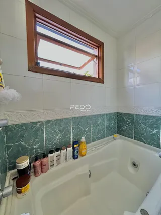 Foto de um banheiro com banheira e janela.