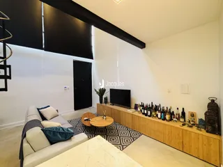 Sala de estar com sofá e rack de madeira em um imóvel no Brasil.