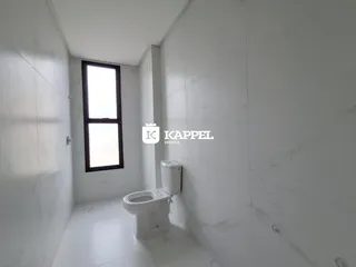 Este é um banheiro com revestimento em mármore branco e piso claro.