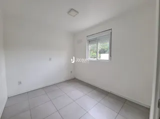 Foto de um cômodo interno com paredes brancas e piso de cerâmica.