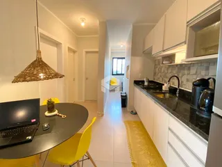 Interior de uma sala de estar com cozinha em um apartamento.
