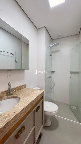 Foto de um banheiro moderno com box de vidro e louças sanitárias.