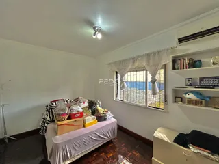Quarto com cama e janela em um imóvel no Brasil.