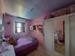 Quarto com paredes rosa e cama em um ambiente interno.