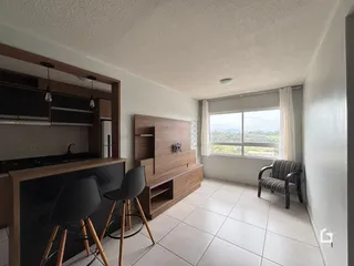 Sala de estar com piso de cerâmica e móveis de madeira em Lajeado.