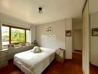 Quarto com janela e piso de madeira no imóvel.