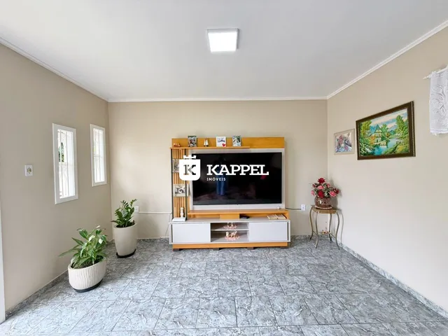 Sala de estar com televisão e piso de cerâmica.