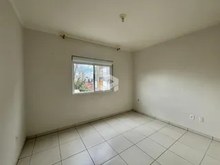 Uma sala de estar com piso de cerâmica clara e janela.