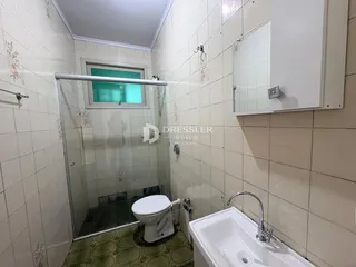 Foto de um banheiro com azulejos brancos e box de vidro.