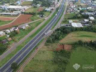 Vista aérea de uma área rural com uma estrada que atravessa o terreno.