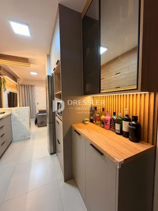 Interior de uma cozinha moderna com armários de madeira e piso claro.