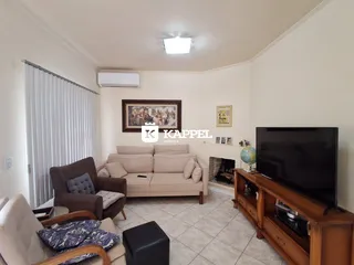 Sala de estar com sofá e televisão em um apartamento.