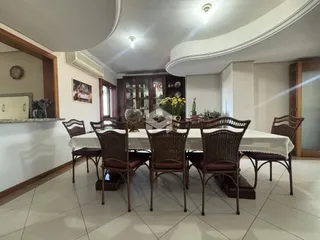 Sala de jantar com mesa e cadeiras de vime.
