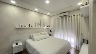 A foto exibe um quarto moderno com cama e decoração branca.
