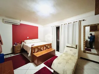 Quarto com parede vermelha e móveis de madeira.