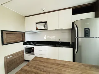 Foto de uma cozinha com armários brancos e bancadas escuras.