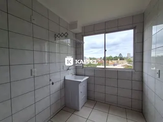 Banheiro com revestimento de azulejos cinza e janela para a vista.