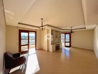 Sala de estar ampla com piso de madeira e portas de vidro.