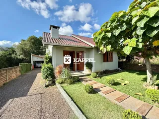 Foto da fachada de uma casa em Lajeado, Brasil, com jardim bem cuidado.