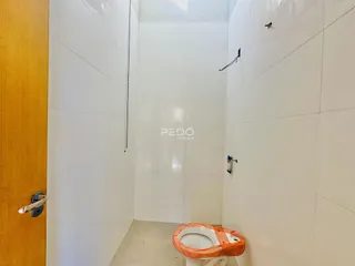 Parede interna de um banheiro com revestimento cerâmico branco.