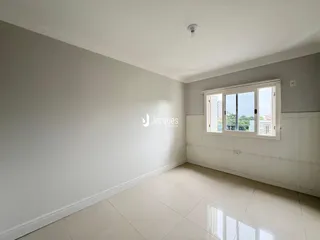 Ambiente interno de uma sala com paredes brancas e piso claro.