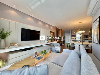 Sala de estar moderna com sofá e televisão em um ambiente bem iluminado.