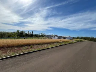 Vista externa da propriedade em Lajeado, com um campo de cultivo ao fundo.