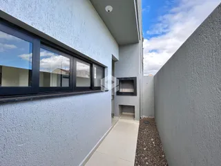 Fachada moderna de uma residência com parede texturizada e janela escura.