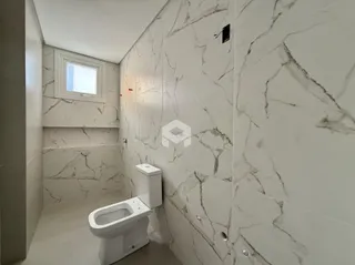Foto de um banheiro com revestimento de azulejos brancos e piso claro.