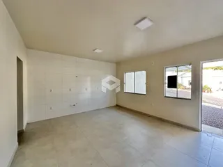 Sala ampla com paredes brancas e piso claro.